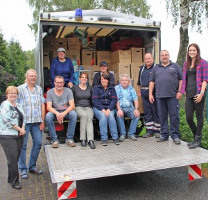 Voll bepackt: Mitglieder der Evangelischen Kirchengemeinde in Sennelager und Sande mit Pfarrerin Elisabeth Goller (4. v. l.) freuen sich den Maltesern 87 Kartons mit Schuhen und andere Sachspenden für die Flüchtlinge in Staumühle überreichen zu können. FOTO: EKP