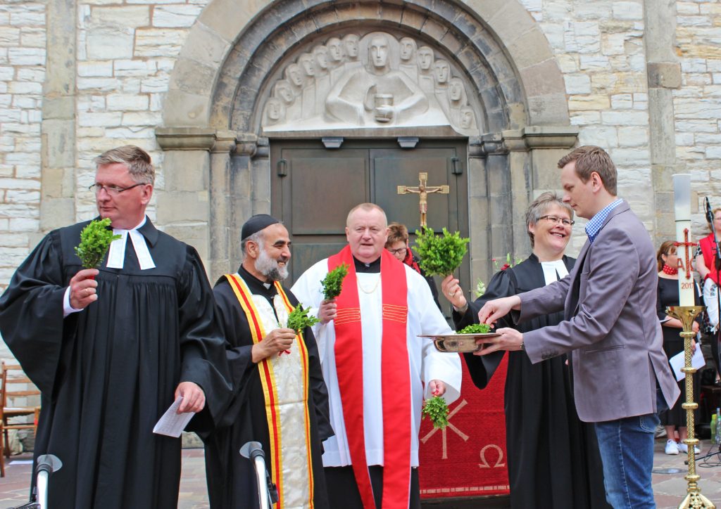 Ökumenischer Gottesdienst mit Tauferinnerung: (v.l.) Pfarrer Gunnar Grahl, Pfarrer A. Ibrahim Araz, Pfarrer Dr. Andreas Schottek, Pfarrerin Sabine Sarpe und David Arngold tauchen Buchsbaum-Gebinde ins Wasser, das an die Taufe erinnert, eine Gemeinsamkeit aller Christinnen und Christen. FOTOS: HEIDE WELSLAU
