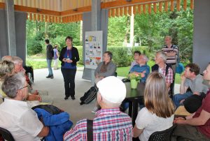 Vielfalt im GlaubensGarten: Pfarrerin Antje Lütkemeier (stehend) erläuterte das Projekt und führte die Umweltbeauftragten durch die sieben Gärten der beteiligten Religionen. Foto: EKP/Oliver Claes.