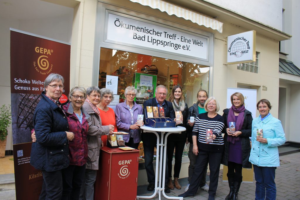 "Freuen sich über die leckere FairTrade-Schokolade (v. r.): Claudia Rupp (Ökumenischer Treff-Eine-Welt e. V.), Dorothea Weber (GEPA-Beraterin), Christel Schuchardt (FairTrade Arbeitskreis), Barny Bürger (FairTrade Arbeitskreis), Julia Harkötter (städtische Mitarbeiterin FairTrade Arbeitskreis), Hans Jürgen Schaefer (Vorsitzender FairTrade Arbeitskreis), Marianne Hesse (FairTrade Arbeitskreis), Angelika Böhm (Ökumenischer Treff-Eine-Welt e. V.) und weitere Interessierte."