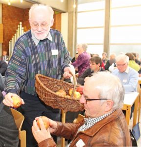 Der Initiator der Apfelbaum-Aktion im Reformationsgedenkjahr 2017, KSV-Mitglied Wolfgang Dzieran, verteilt Äpfel an die Synodalen. FOTO: OLIVER CLAES