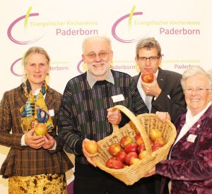 Mitglieder des Kreissynodalvorstands warben mit Äpfeln, die das neue Kirchenkreis-Logo zeigen, auf der Synode für die Aktion „Apfelbäume pflanzen“: (v. l.) Angela Thater (Warburg), Wolfgang Dzieran (Bad Lippspringe), Superintendent Volker Neuhoff und Helga Weber-Kruck (Steinheim). FOTO: HEIDE WELSLAU