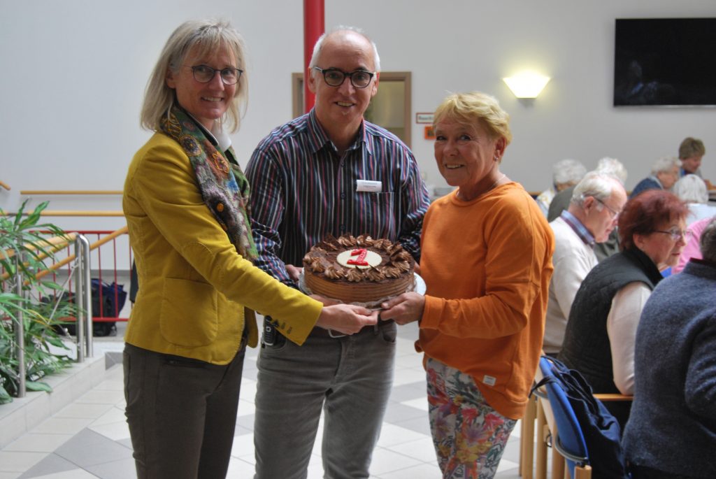 „Mittagstisch und Mehr“: (v. l.) Regina Schepe, gestaltet das Rahmenprogramm des Mittagstisches, Longinus Lomp, Einrichtungsleiter Altenhilfe Paderborn und Inge Griebsch, Ehrenamtliche der Altenhilfe freuen sich über den ersten Geburtstag des Angebotes. Foto: St. Johannisstift