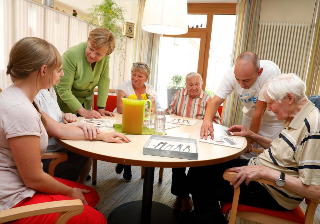 Bundeskanzlerin Angela Merkel und Altenpfleger Ferdi Cebi Im Sophie Cammann-Haus, Einrichtung für Demenzkranke, im Gespräch mit Bewohnern. Foto: Hilla Südhaus