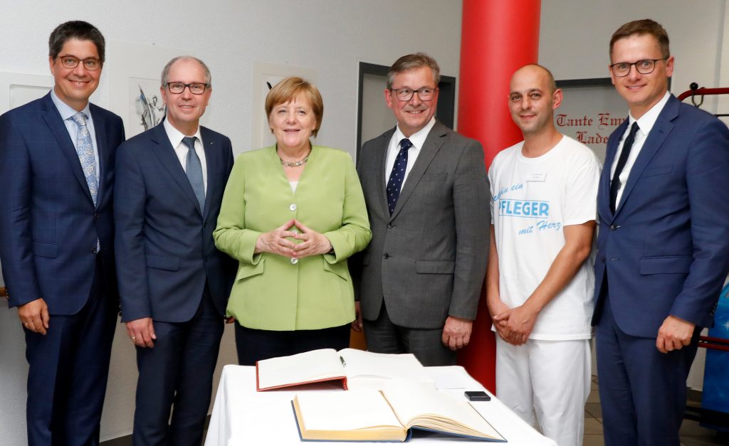 Der Eintrag im goldenen Buch vom Kreis Paderborn und der Stadt Paderborn mit (v. l.) Martin Wolf, Vorstandssprecher St. Johannisstift, Landrat Manfred Müller, Bundeskanzlerin Angela Merkel, Bürgermeister Michael Dreier, Ferdi Cebi, Altenpfleger St. Johannisstift und Bundestagsabgeordneter Carten Linnenmann. Foto: Hilla Südhaus