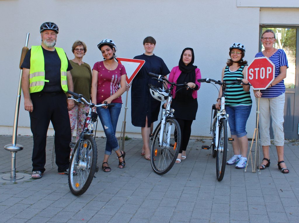 Beim Fahrradkurs: Raimund Gödde, Verkehrswacht Paderborn (v. l.), Christiane Rammig, ehrenamtliche Mitarbeiterin Projekt PIA der Bürgerstiftung Paderborn, Johanna Leifeld, Kommunales Integrationsbüro Kreis Paderborn (Mitte), Susanne Bornefeld, Evangelische Erwachsenenbildung (r.) und drei der Teilnehmerinnen des Fahrradkurses. Foto: EKP/Oliver Claes