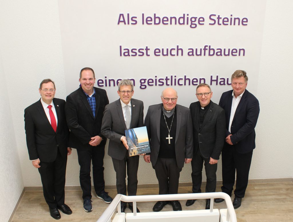Beim Besuch im Haus der Evangelischen Kirche: (v. l.) Synodalassessor Gunnar Wirth, Dekanatsreferent Rainer Fromme, Superintendent Volker Neuhoff mit dem Buchgeschenk des Gastes über den Paderborner Dom, Weihbischof Hubert Berenbrinker, Dechant Benedikt Fischer und Pfarrer Gunnar Grahl. Foto: EKP/Oliver Claes