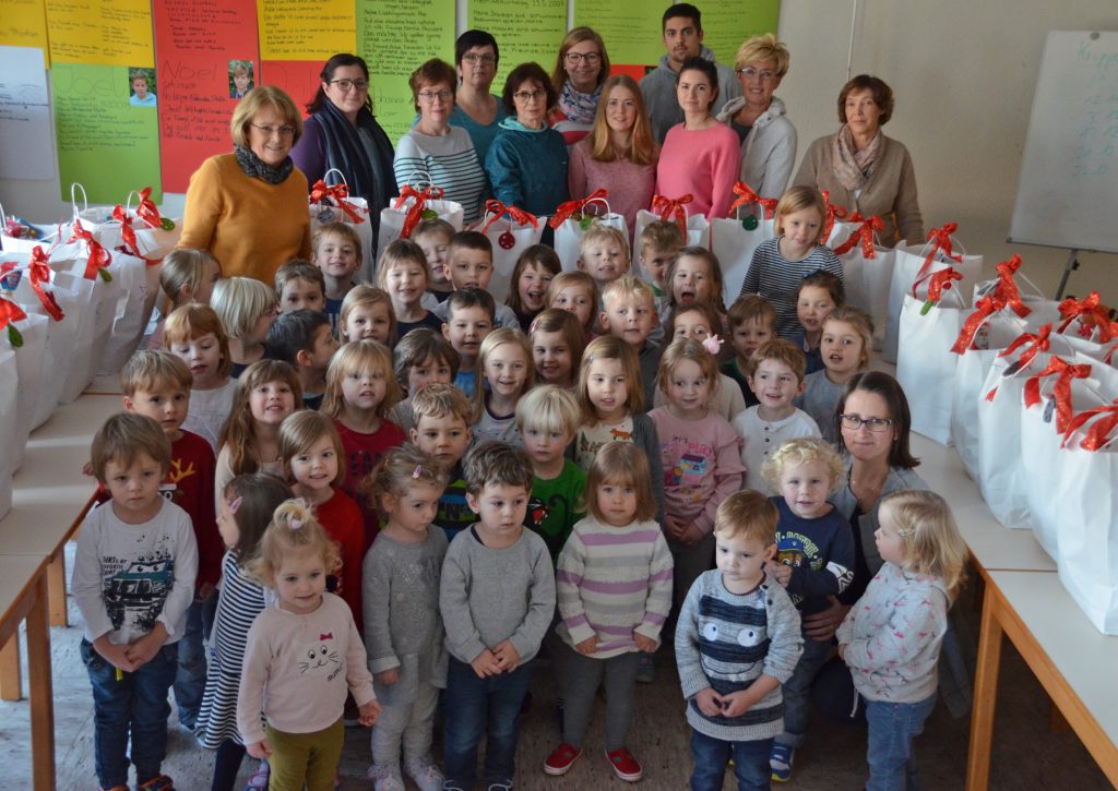 Lebensmittelgeschenke: Die Kinder des Evangelischen Familienzentrums Abdinghof freuen sich mit den Erzieherinnen und ihrer Leitung Astrid Markwort (Mitte links) über die prall gefüllten Weihnachtstüten, die von Doris Moosburger (rechts), der Koordinatorin der Paderborner Tafelausgabe am Abdinghof, an die Tafelgäste verteilt wurden. FOTO: ECKHARD DÜKER