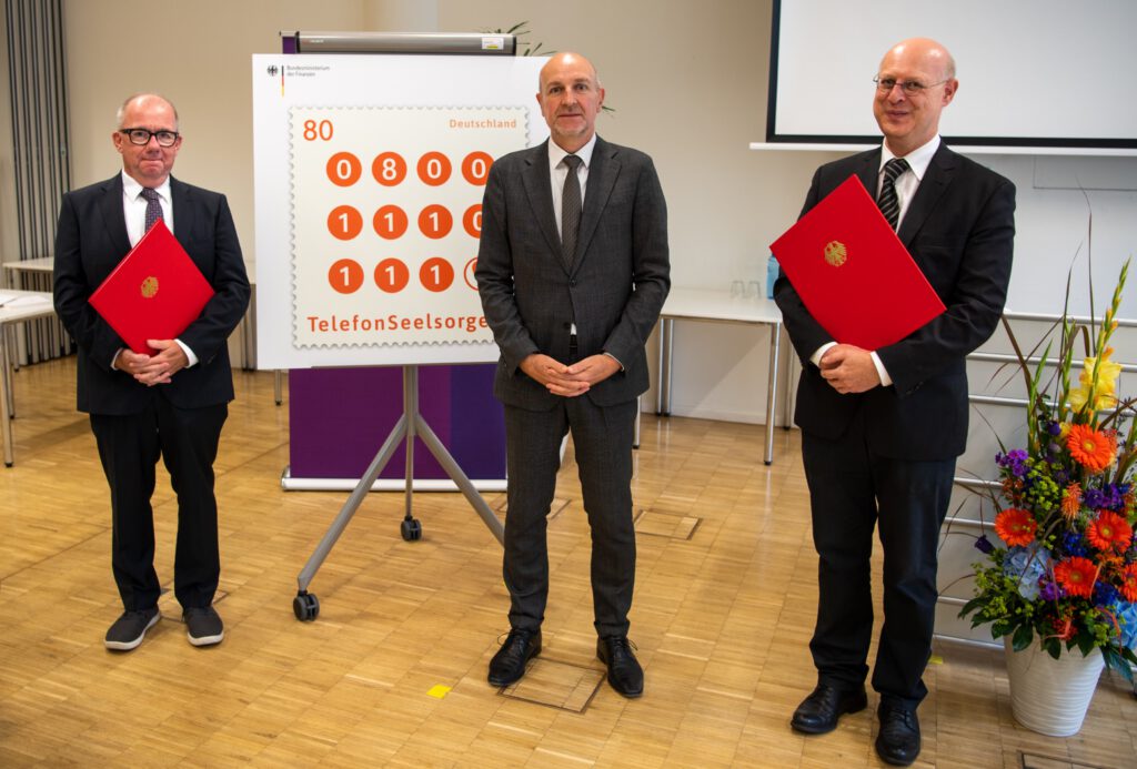 Bei der Präsentation der Sonderbriefmarke: (v. l. ) Pfarrer Dr. Frank Ertel, Staatssekretär Dr. Rolf Bösinger, Bundesministerium der Finanzen und Dr. Jörg Kruttschnitt, Finanzvorstand der Diakonie Deutschland. Foto: Telefonseelsorge Deutschland