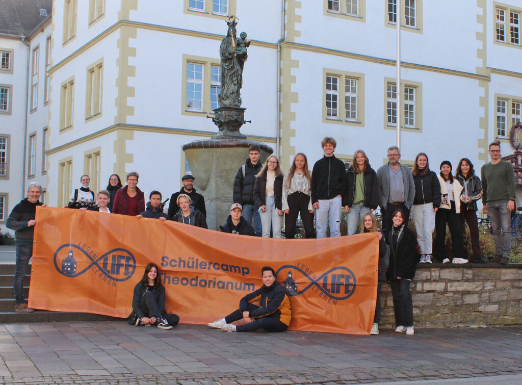 Freuen sich über die Zusammenarbeit beim Schülercamp: Schülerinnen und Schüler des Theodorianums, die aktuell an der Teamer-Ausbildung teilnehmen sowie Dr. Frank Bretschneider, Leiter des Schülercamps (l.), Schulleiterin Nicole Michaelis, Gymnasium Theodorianum (5. v. l.), Hendrik Zernke, Jugendreferat Evangelischer Kirchenkreis Paderborn (7. v. l.), Burkhardt Nolte, Leiter Schulreferat Evangelischer Kirchenkreis Paderborn (5. v. r.) und Dain Czeszak, Leiter des Schülercamps (r.). Foto: EKP/Oliver Claes