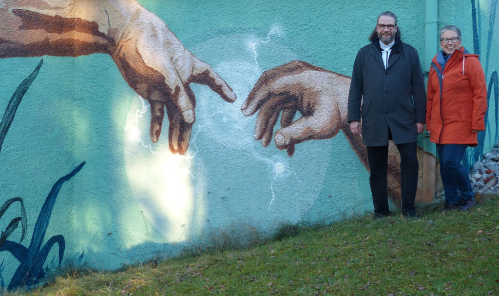 Ein echter Hingucker: Das großflächige Graffiti, das zur Zeit an der Paul-Gerhardt-Kirche entsteht. Die Erschaffung Adams – frei nach Michelangelo, interpretiert vom Graffiti-Künstler Eddie Bormann. Foto. Ev. Kirchengemeinde Schloß Neuhaus