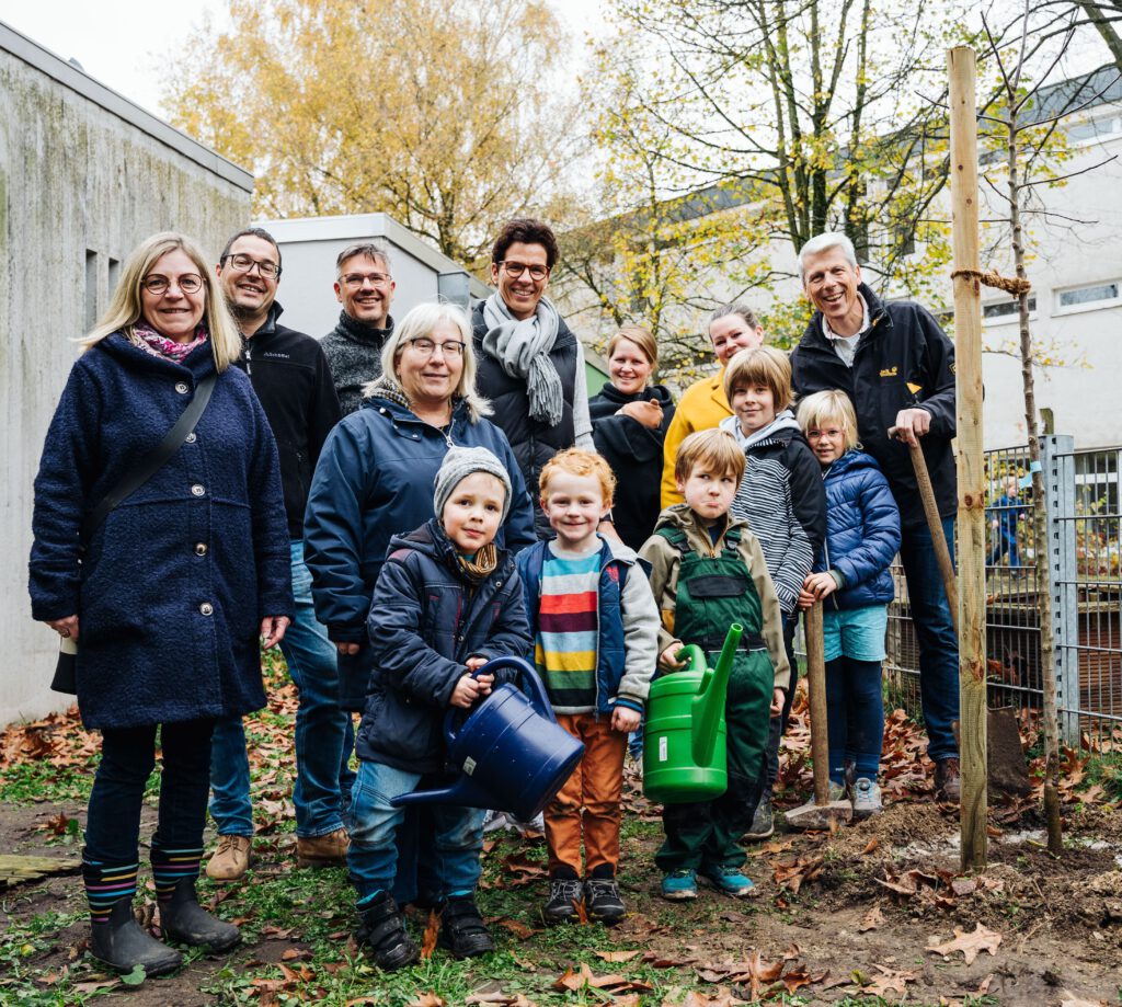 Erfolgreich einen Apfelbaum gepflanzt haben die Kinder und das Team der katholischen Kita St. Kilian gemeinsam mit den Lions-Mitgliedern Dr. Dennis Kundisch (Präsident), Andreas Stiewe, Dr. Claudia Beverungen (hinten v. l.) und Thomas Rikus (hinten rechts). Foto: Lions Club