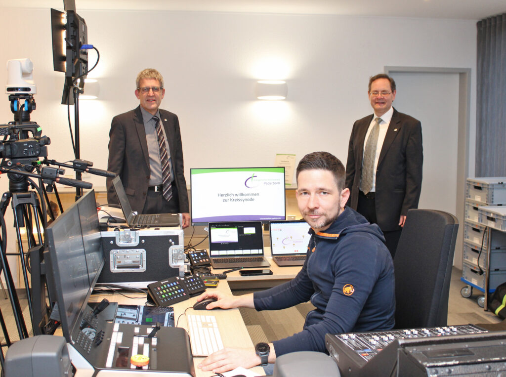 Im Senderaum der digitalen Kreissynode im Haus der Evangelischen Kirche: Superintendent Volker Neuhoff (l.) und Synodalassessor Gunnar Wirth (r.) sowie David Heuer, Broadcast & Event (M.), der die Online-Tagung technisch umgesetzt hat. Foto: EKP/Oliver Claes