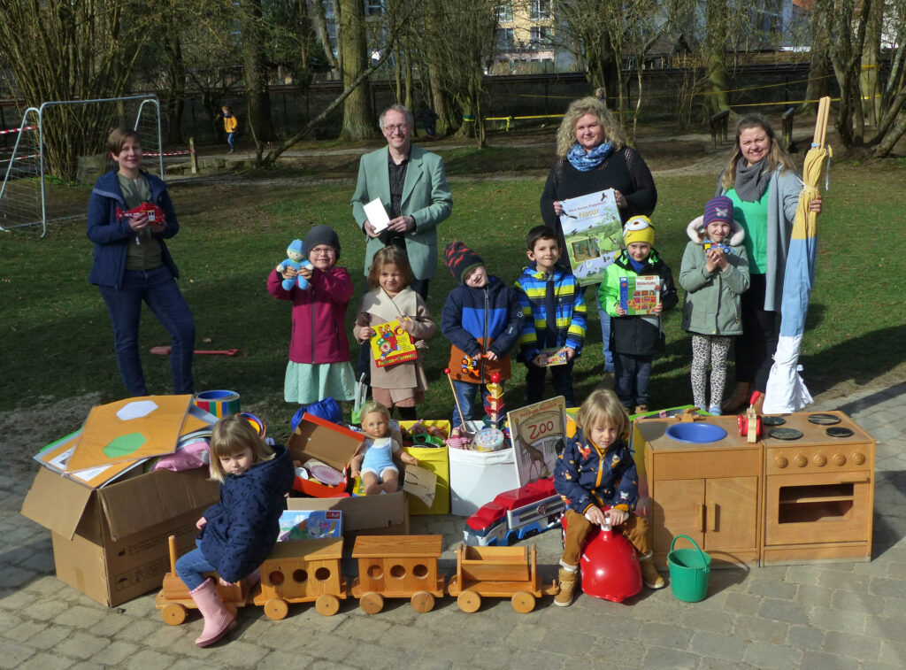 Freuen sich über die gelungene Spendenaktion: Kinder aus dem evangelischen Familienzentrum „Jesus und Zachäus“ sowie (v. l.) die Gleichstellungsbeauftragte Frederike Wieneke, Sozialamtsleiter Markus Pitz, Kita-Leiterin Sandra Wiedey und Erzieherin Kristin Lücke. Foto: Familienzentrum „Jesus und Zachäus“