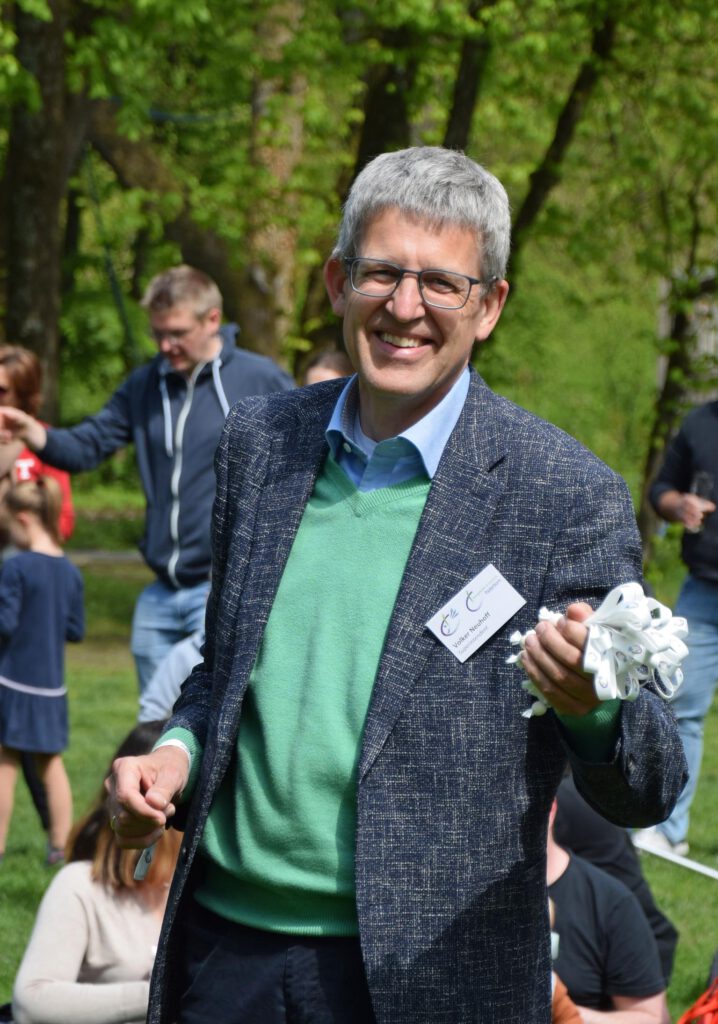 Superintendent Volker Neuhoff verteilte Armbänder mit dem neuen Kinderlogo des Kirchenkreises an die Besucher. Foto: Jan Globacev