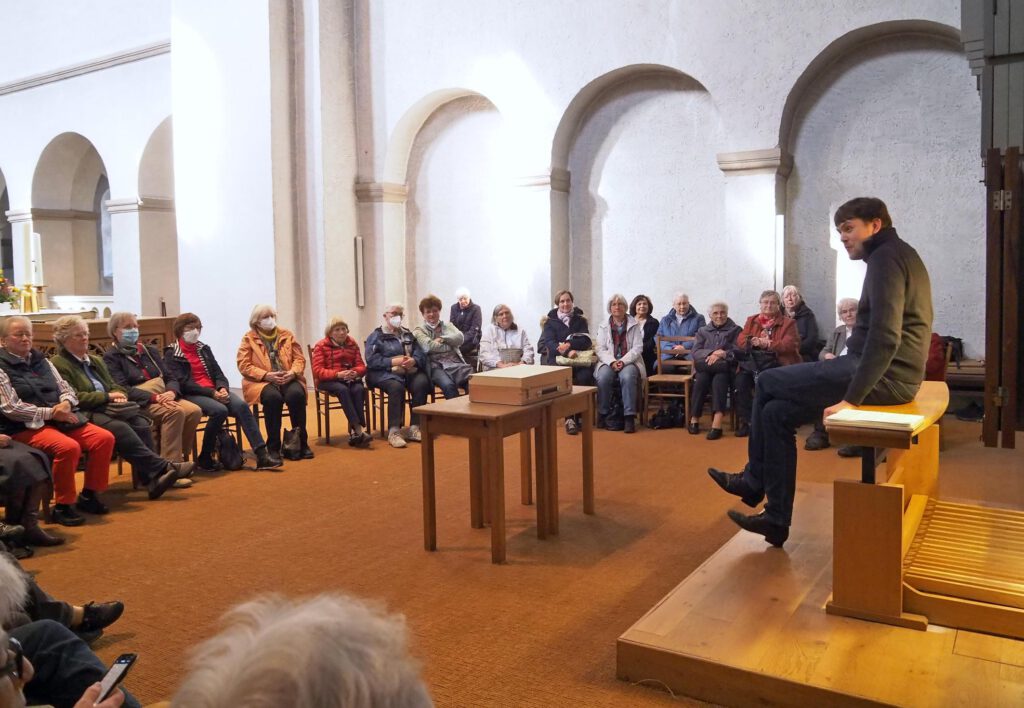 Kantor Tim Gärtner erklärt die Orgel der Abdinghofkirche. Die Frauenhilfeschwestern hören gebannt zu. Foto: Ev. Frauenhilfe