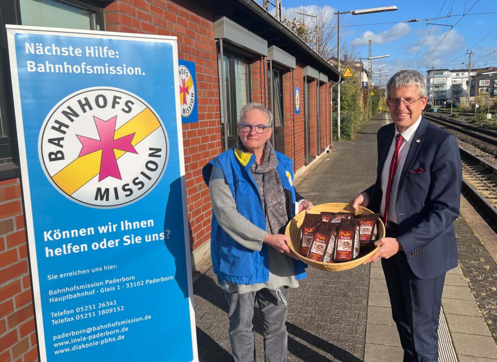 Superintendent Volker Neuhoff übergibt die Kaffeespende an Sabine Bergmaier, Leitung der Bahnhofsmission Paderborn. Foto: EKP/Jan-Hendrik Noll