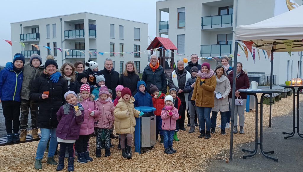 Inmitten von Kindern und Eltern: (Mitte von links) Dieter Honervogt (stellvertretender Bürgermeister), Jessica Schütte (Amt für Umweltschutz und Grünflächen der Stadt), Heiner Bredt (Evang. Lukas-Gemeinde), Pfarrer Rüdiger Rasche (kath. St. Hedwig-Gemeinde) und Sören Becker (kath. Pastoralreferent PB-Mitte-Süd).Foto: Lukas-Pfarrbezirk