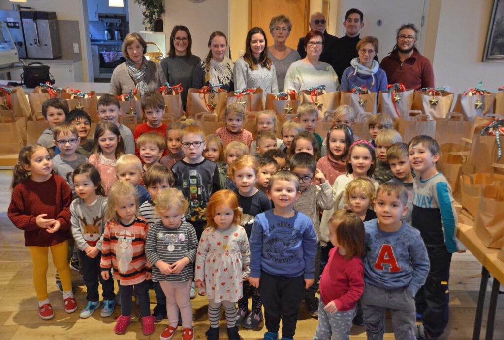 Die Kinder des Evangelischen Familienzentrums Abdinghof freuen sich mit den Erzieherinnen und Erziehern und ihrer Leitung Irina Wichert (2.v. links) über die prall gefüllten Weihnachtstüten, die von Doris Moosburger (links), der Koordinatorin der Paderborner Tafelausgabe am Abdinghof, und Ulrich Gruß (rechts) an die Tafelgäste verteilt wurden.Foto: Eckhard Düker