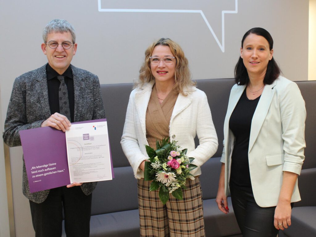 Superintendent Volker Neuhoff (l.) übergab im Beisein von Diakonie-Vorstand Vanessa Kamphemann (r.) das Zertifikat über die erfolgreiche Qualifizierung als Multiplikatorin für Schulungen im Bereich sexualisierte Gewalt an Astrid Schäfers, Präventionsbeauftragte der Diakonie.Foto: EKP/Oliver Claes