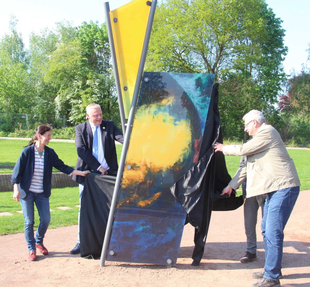 Künstlerin Sigrid Vischedyk, Bürgermeister Daniel Hartmann und Schöpfungsgarten-Organisationsleiter Reinhard Großkopf von der evangelischen Kirchengemeinde enthüllen die Skulptur „HimmelsWelt“.Foto: Burkhard Battran 