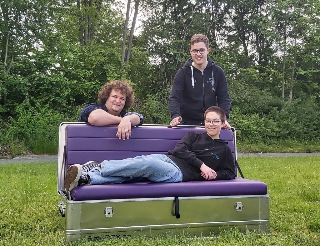 Kirche zum Aufklappen: Der neue Couchkirche des Jugendreferates im Evangelischen Kirchenkreis Paderborn hat ihre Premiere im Paderquellgebiet. Darauf freuen sich Jonas Mischendahl (v. l.), Joel Leis und Noa Nölken vom Vorbereitungsteam.Foto: Jugendreferat