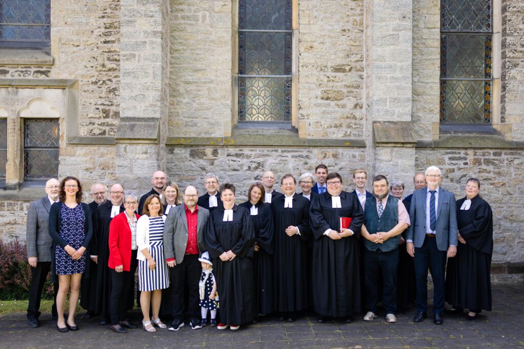 Pfarrerin Kira Weweler (vorne Mitte) wurde am Pfingstmontag durch Superintendent Volker Neuhoff (hinten Mitte) ordiniert. Menschen, die sie auf ihrem Weg begleitet und unterstützt haben, nahmen an der Ordination in der evangelischen Kirche in Steinheim teil.Foto: www.tobiaslange.art