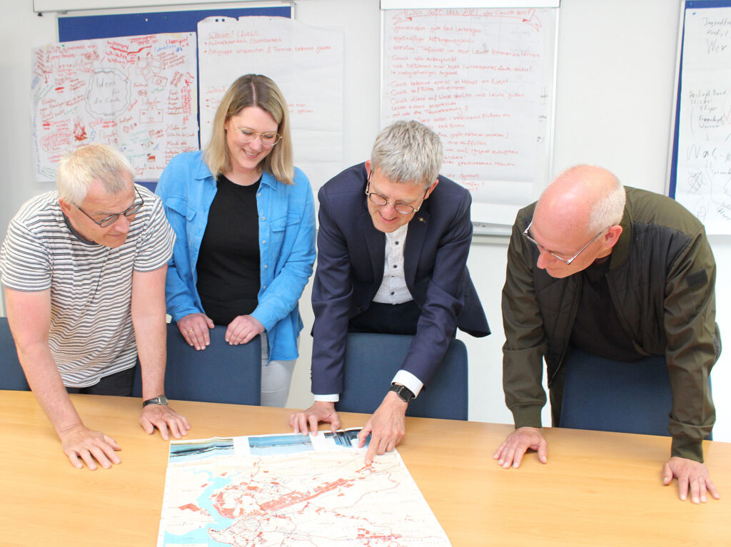 Bei den Reisevorbereitungen: Pfarrer Karl-Edzard Buse-Weber, Jugendpfarrerin Melanie Freye, Superintendent Volker Neuhoff und Jugendreferatsleiter Oliver Schwarz mit einer Karte von Dar es Salaam, wo ihr Flugzeug landen wird.Foto: EKP/Oliver Claes