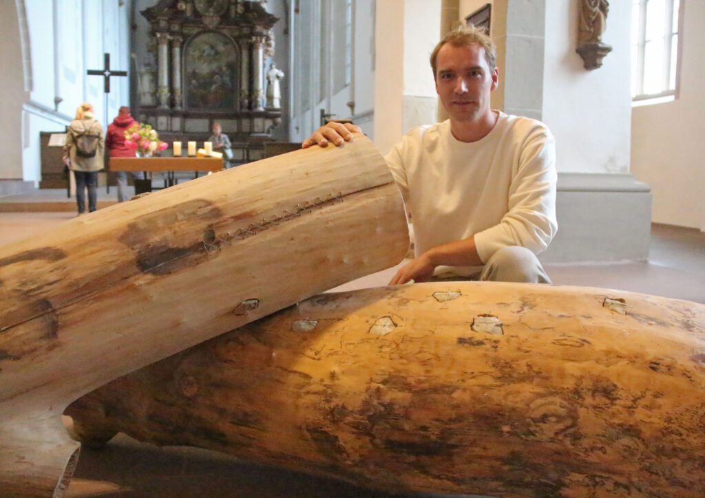 Künstler Cengiz Hartmann und seine Installation „Menschwerdung“ in der Mitte des Kirchenraums.Foto: Burkhard Battran