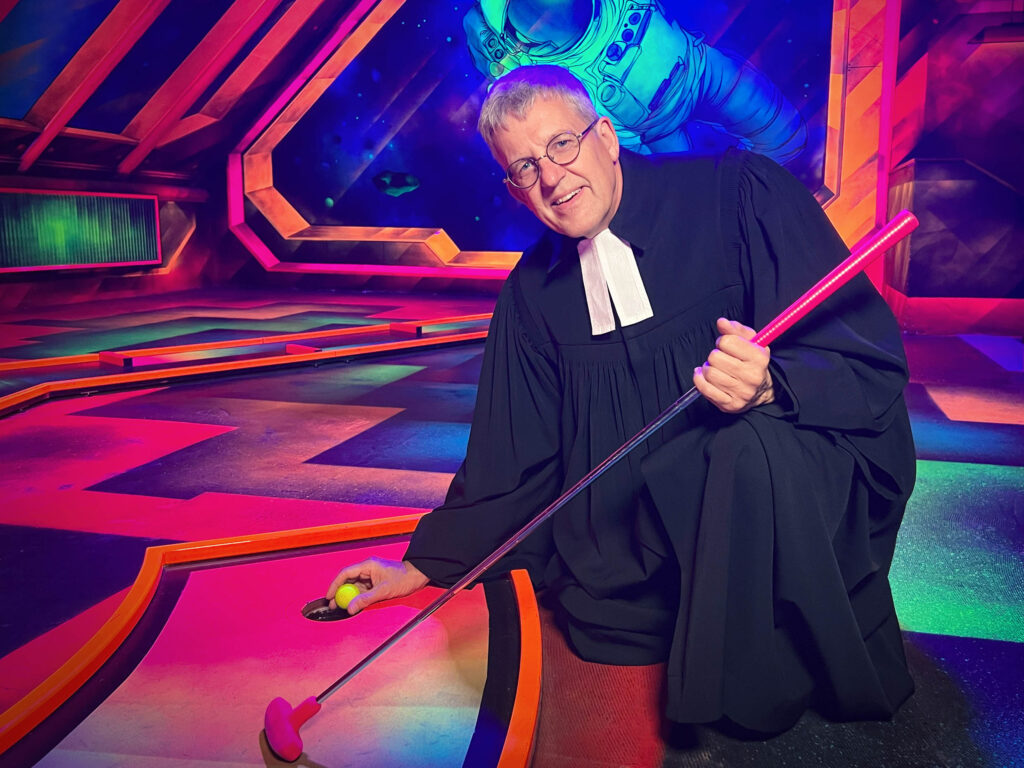 Superintendent Volker Neuhoff macht den ersten Aufschlag zum Projekt „KircheWoAnders“ des Evangelischen Kirchenkreises Paderborn, das neue Ideen fördert. Es geht um Kirche in anderer Form und an ungewöhnlichen Orten, wie zum Beispiel hier beim 3D Schwarzlicht Minigolf im Erlebnispark Meiwes in Delbrück. Foto: EKP/Jan-Hendrik Noll