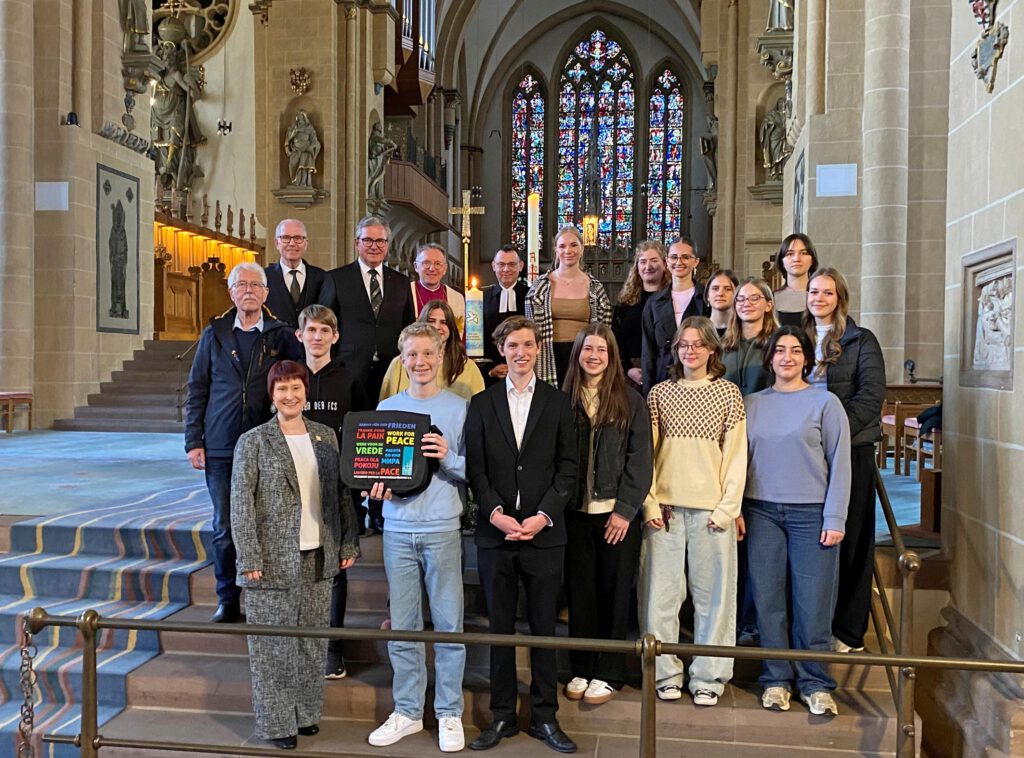 Teilnehmende des Gedenk-Gottesdienstes im Paderborner Dom mit Friedenskerze.