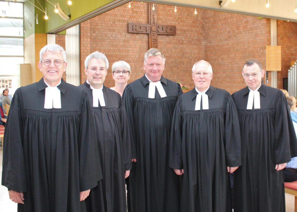 Gruppenbild von Pfarrerinnen und Pfarrern im Talar im Kirchraum des Martin-Luther-Zentrums Paderborn.