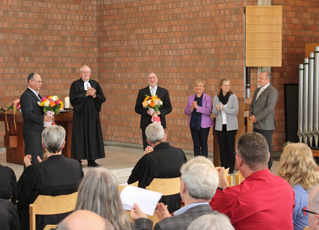 Mitarbeitende des Martin-Luther-Bezirks werden im Kirchraum verabschiedet und erhalten Blumensträuße.