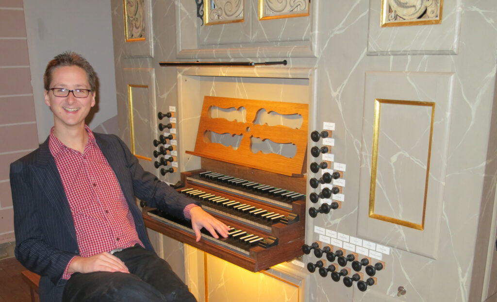 Ein Kirchenmusiker sitzt an der Orgel.