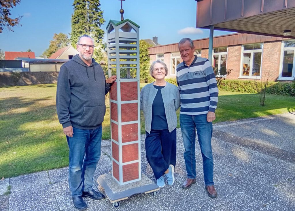 Mitglieder des Turmbauvereins in Schloß Neuhaus mit einem Modell des Kirchturms.