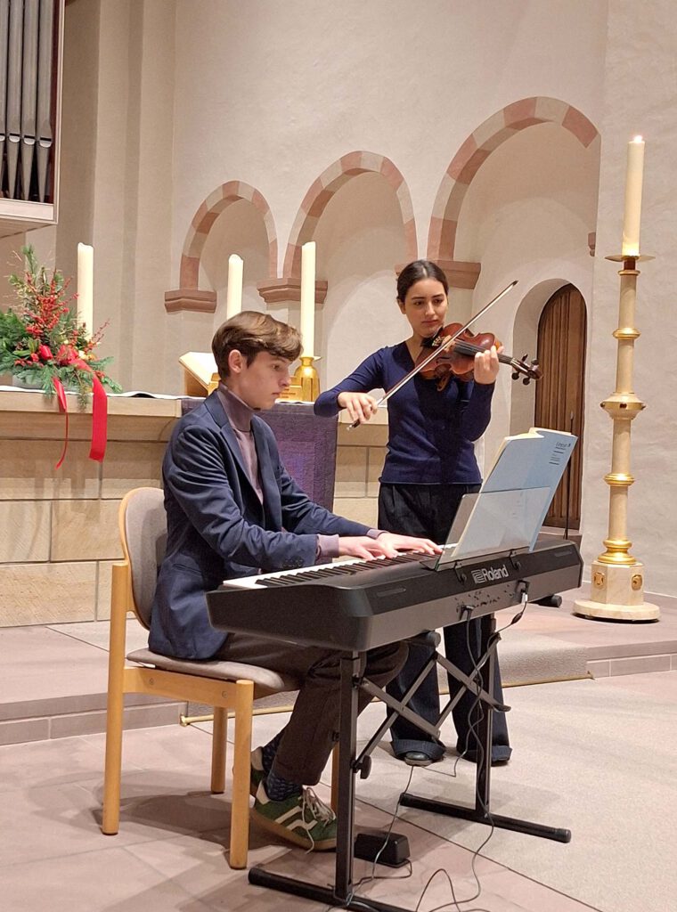Die beiden beteiligten jungen Musiker spielen im Altarraum der Abdinghofkirche mit Keyboard und Geige einen Ausschnitt aus dem geplanten Benefizkonzert.