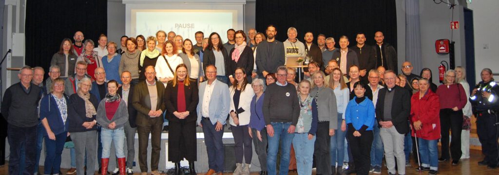 Alle über 80 Teilnehmenden der Sozialkonferenz auf der Bühne im Veranstaltungsraum.