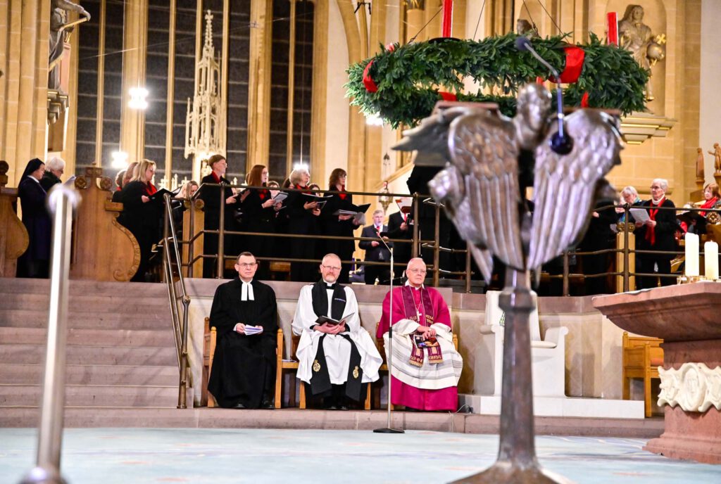 Die am Gottesdienst beteiligten Geistlichen sitzen im Altarraum des Paderborner Domes.