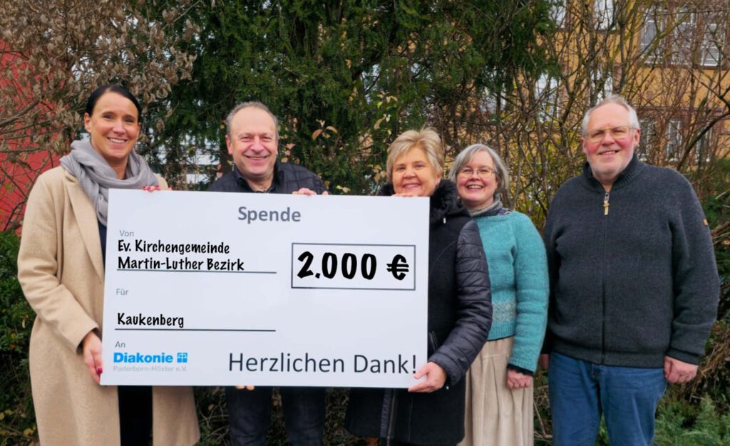Die Beteiligten halten den symbolischen Spendenscheck.