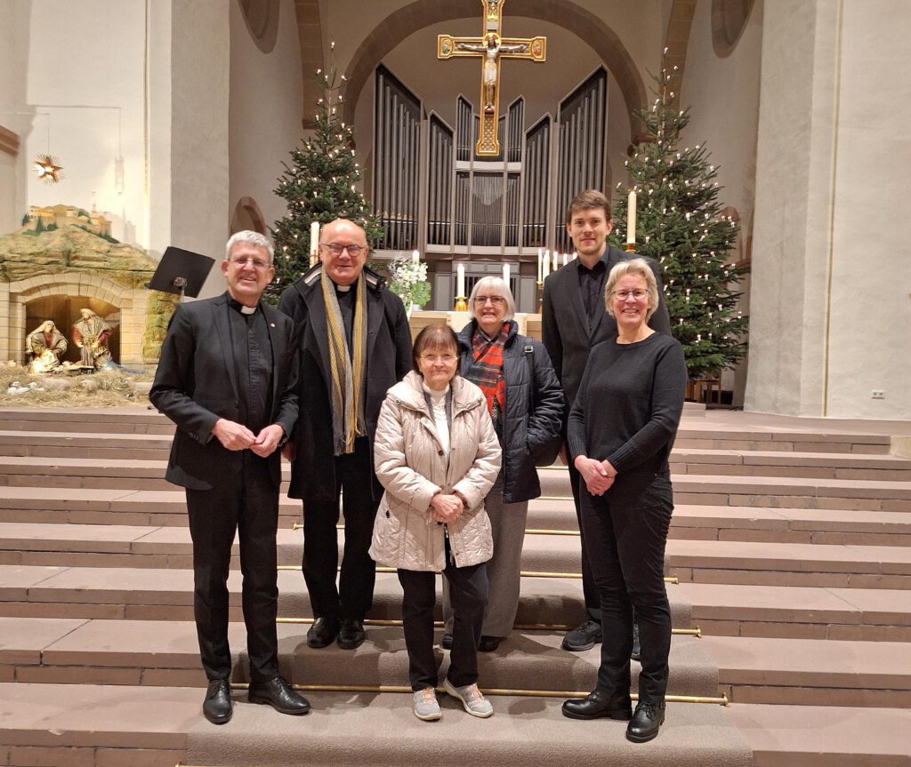 Frauen und Männer, die am Gottesdienst mitwirkten, auf den Stufen vor dem Altarraum.