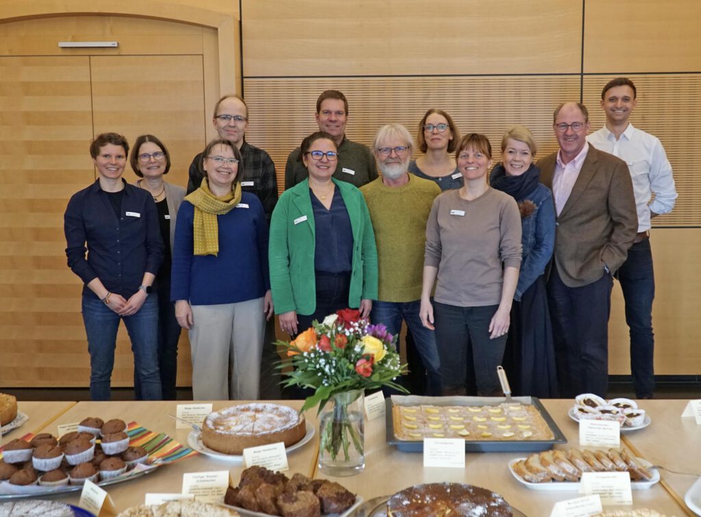 Menschen aus der Gruppe Faires Paderborn stehen hinter einem Tisch mit Kuchen.