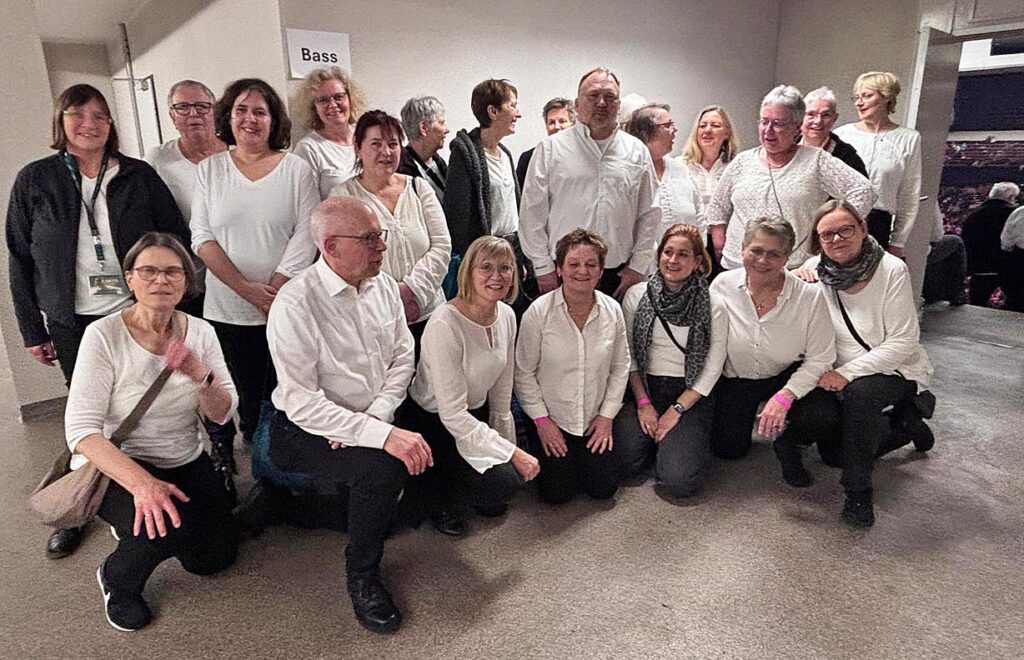 Die 30 Sängerinnen und Sänger aus Borchen haben sich hinter der Bühne aufgestellt.