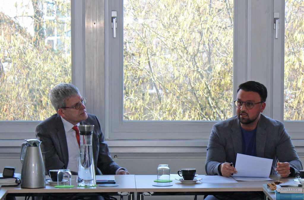 Der Referent und Zuhörende in einem Konferenzraum.