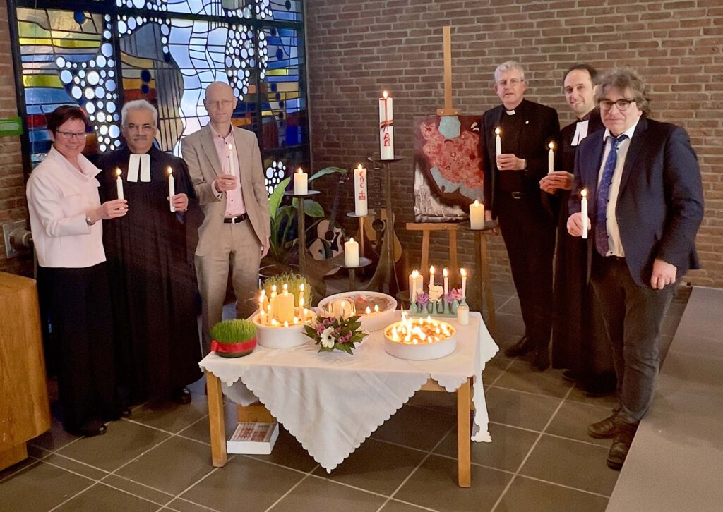 Menschen halten brennende Kerzen in ihren Händen.