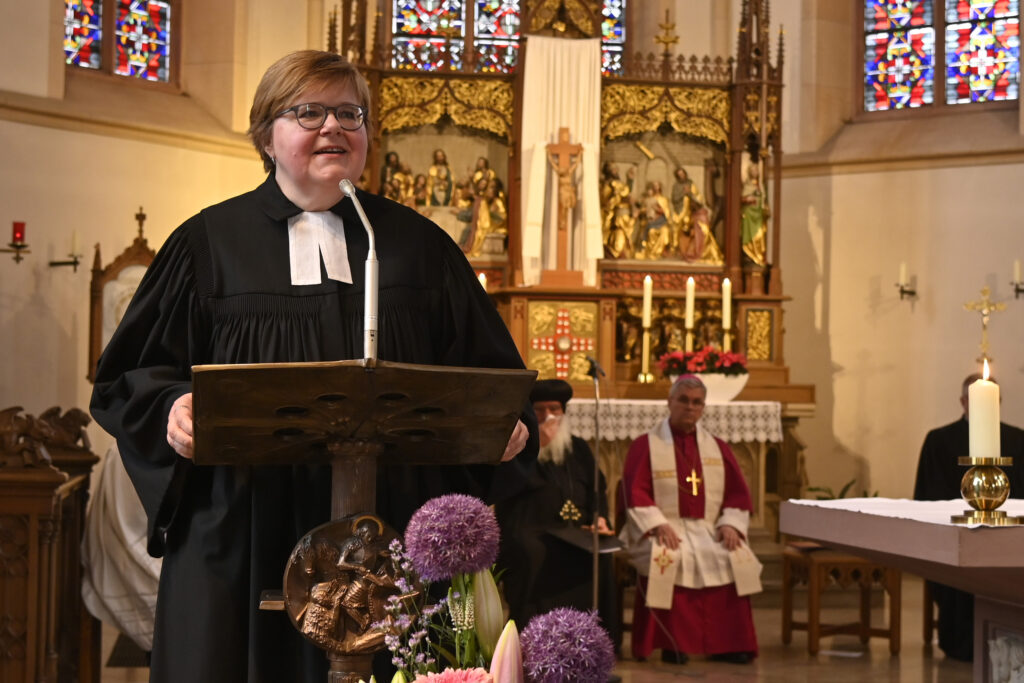 Eine evangelische Theologin hält an der Kanzel in einer Kirche ihre Predigt.