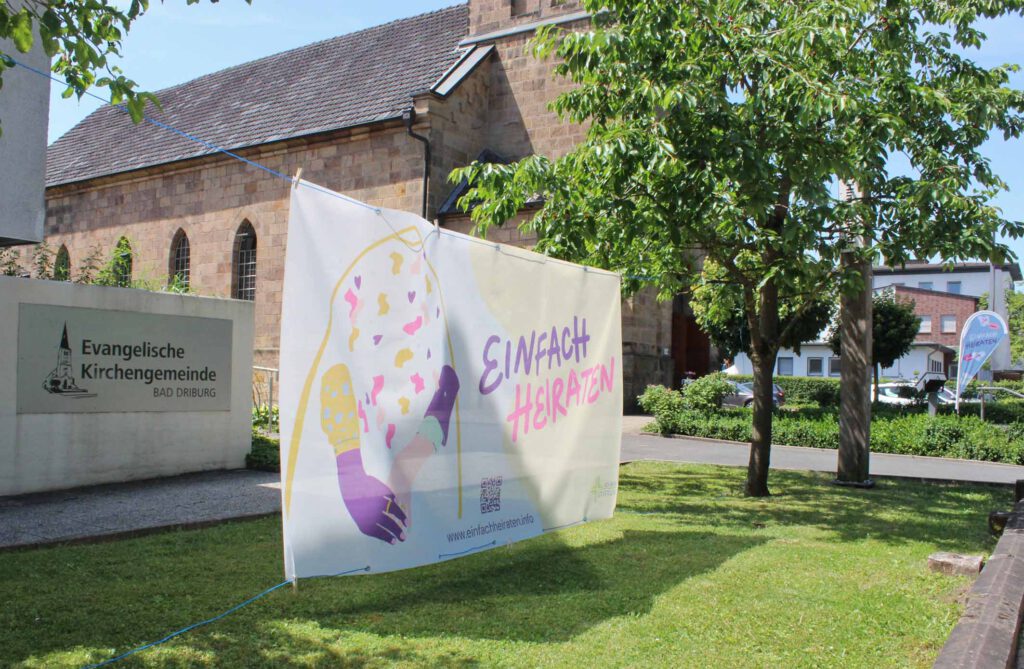 Ein Banner und eine Flagge mit dem Schriftzug "einfach heiraten" von der Evangelische Kirche in Bad Driburg.