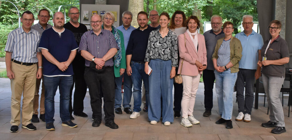 Eine große Gruppe Männer und Frauen hat sich für ein Foto aufgestellt.