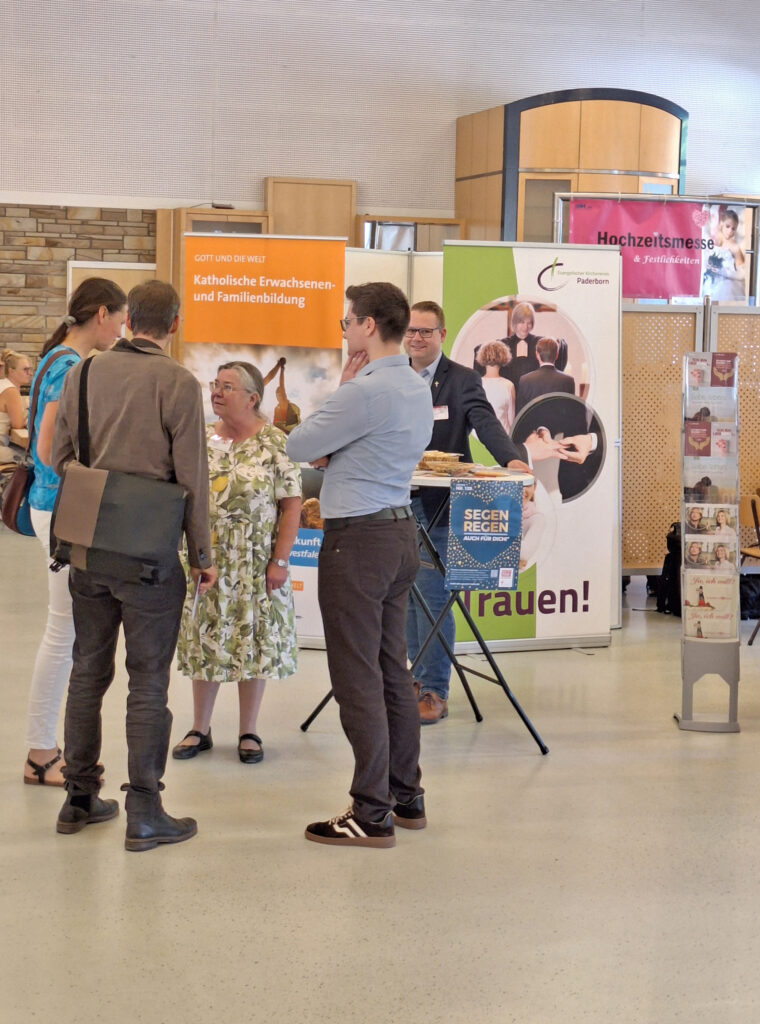 Menschen im Gespräch an einem Messestand.